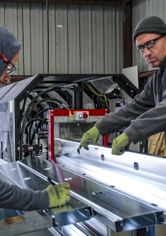 Operator running steel through the roll-forming machine at NonCombustibles